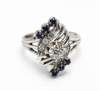a close up of a diamond and sapphire ring on a white background