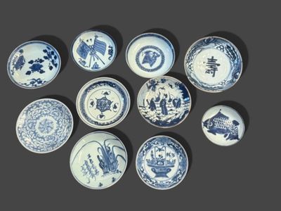 several blue and white plates are arranged in a circle on a gray surface