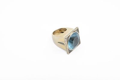 a close up of a gold ring with a blue topaz stone
