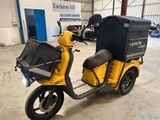 un scooter jaune avec un coffre noir à l'arrière
