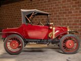 a red car parked in front of a brick wall