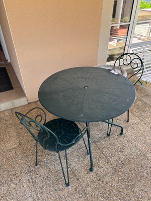 une table et des chaises sur la terrasse à l'extérieur d'un immeuble