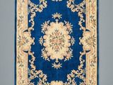 a close up of a blue rug with a floral design on it