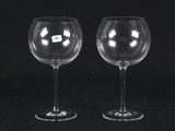 pair of clear wine glasses on a black background