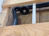 a close up of a wooden bed frame with a metal rail