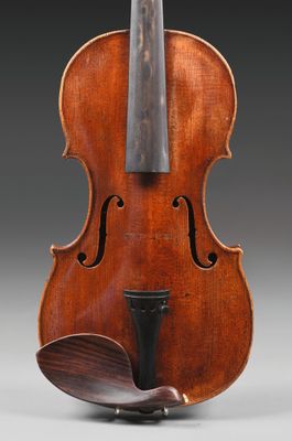 un vieux violon sur lequel repose un archet en bois