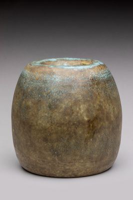 a close up of a vase on a white surface