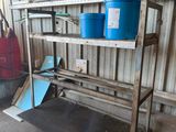 a metal shelf with two blue buckets on top of it