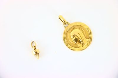 a gold pendant with a picture of a woman on it