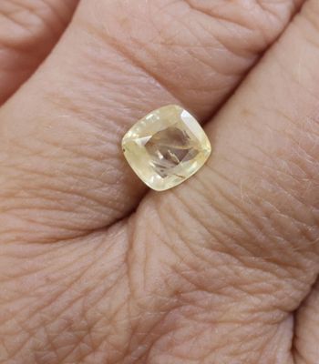 a close up of a person ' s hand holding a yellow diamond