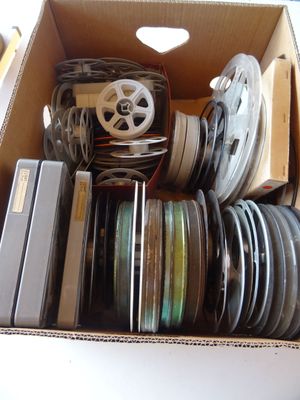 une boîte remplie de bobines de film posée sur une table