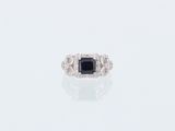 a black and white diamond ring on a white surface