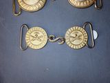 three brass plated watches and a keychain on a blue surface