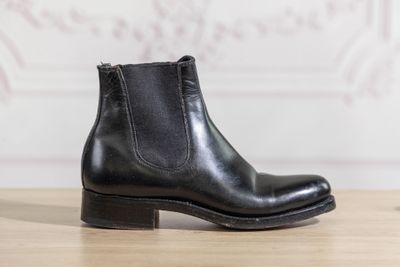 a close up of a pair of black leather boots on a wooden table