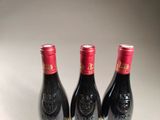 three bottles of wine sitting on top of a table next to each other