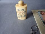 a small bottle with a picture on it next to a pair of scissors
