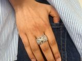someone is holding a ring in their pocket while wearing a blue shirt