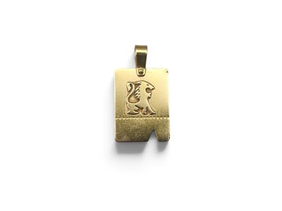 a close up of a gold pendant with a dog on it