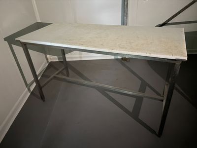 une table blanche avec un plateau en marbre dans une pièce