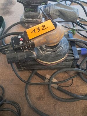une photo d'une ponceuse et d'autres outils posés sur une table