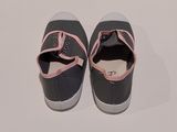 une paire de chaussures noires et roses avec des lanières roses sur un fond blanc
