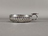 silver plated ring with twisted design on a plain surface