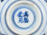 a close up of a blue and white bowl with writing on it