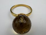 a close up of a ring with a brown stone on it