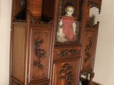 a china cabinet with a doll on top of it