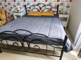 un lit à structure métallique dans une chambre au papier peint à motifs floraux