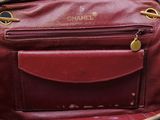 a red purse with a gold chain hanging from it ' s handle