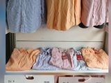 a lot of shirts hanging on a rack in the closet