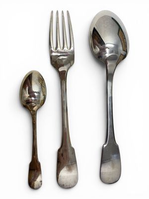 three spoons and a fork on a white surface