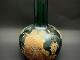 un vase vert orné d'un motif doré