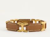 un bracelet en cuir marron avec un fermoir plaqué or