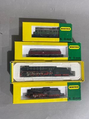 trois boîtes contenant des trains miniatures posées sur une table