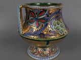 a gold and blue vase with a flower design on it