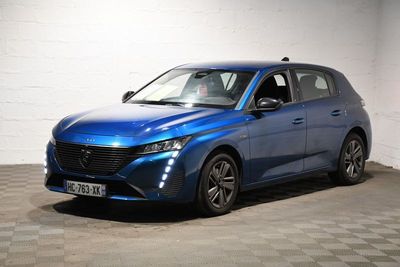 une voiture bleue est garée dans une pièce au sol à carreaux