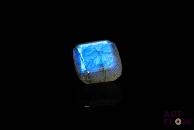 a close up of a blue stone on a black surface