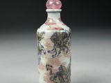 a small bottle with a painting on it sitting on a table