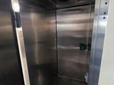 a metal elevator with a door open in a building