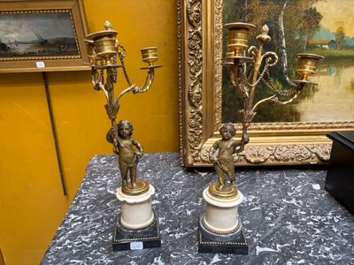 Paire de bougeoirs à trois bras de lumière supportés par deux puttis e