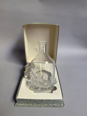 une petite bouteille en verre dans une boîte posée sur une table