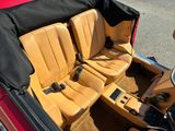 a red car with a black top and tan leather seats