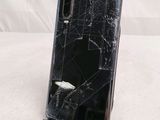 a broken cell phone sitting on a stand on a table