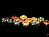 some very pretty colored gems on a black surface