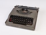 an old typewriter sitting on top of a white surface
