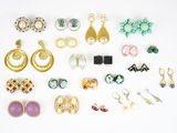 de nombreuses paires de boucles d'oreilles disposées sur une surface blanche