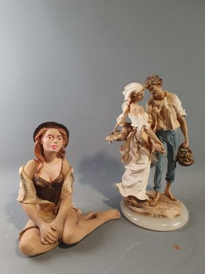 deux figurines représentant un homme et une femme assis par terre