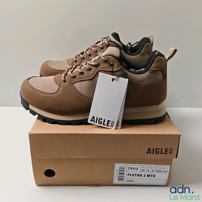 la chaussure est posée sur une boîte sur laquelle est accrochée une étiquette